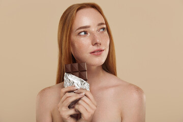 Ginger girl with naked shoulders and chocolate
