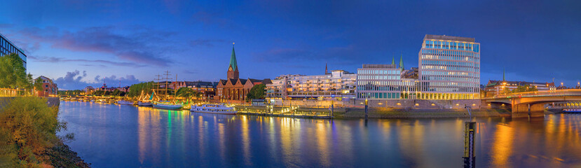 Panorama view of  harbour along the Schlachte Embankment and  Martinianleger by Bremen. View of Bremen riverside, Weser river, Schlachte promenade by evening. Skyline from Bremen with St. Martini. - obrazy, fototapety, plakaty