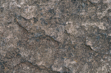 Rough surface old wall, fine granite stone mixed with biton mortar, textured background closeup, exposure to atmosphere,