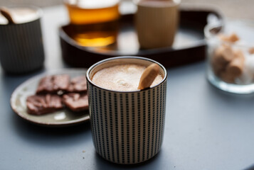 Coffee cream in a modern ceramic cup on a gray table in a cafe. Close-up with blurred background.