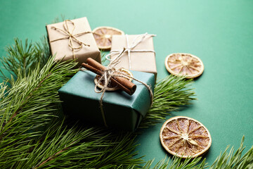 Christmas gift boxes and pine tree branches with decoration on green