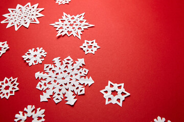 Christmas decoration with white paper snowflakes on red