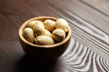 Pecan nuts in bowl on wooden table