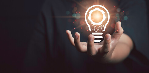 Innovation idea and knowledge concept. Hand hold gear icon in light bulb icon of ​​inspiration thinking.