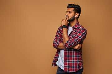 Young handsome indian man in casual close with crossed arms on pastel background with copy space