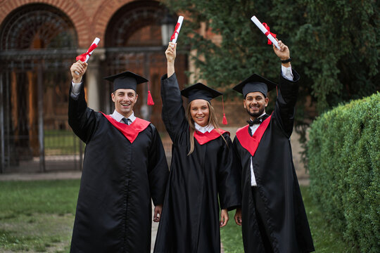 Happy International Graduates From Different Countries Celebrating Diplomas In Graduation Robes