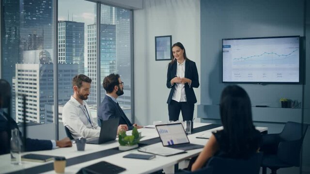 Diverse Office Conference Room Meeting: Successful Female Executive Director Presents e-Commerce Fintech Growth Statistics to a Group of Investors. Wall TV with Big Data Analysis, Infographics