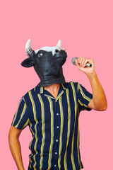 man wearing a cow mask speaking into a microphone