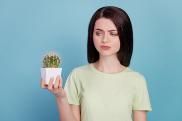 Photo of young pretty lady unhappy moody look flower plant cactus care isolated on turquoise color...