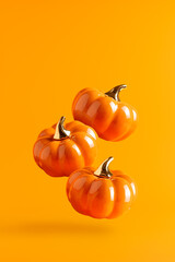 Three levitating ceramic pumpkins on orange background. Vertical Halloween banner.