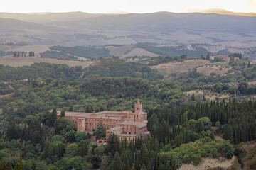 Fototapeta na wymiar Chiusure, Asciano (SI), Italy - August 15, 2021: Landscape view from Chiusure village and Monteoliveto Maggiore Abbey, Asciano, Tuscany, Italy