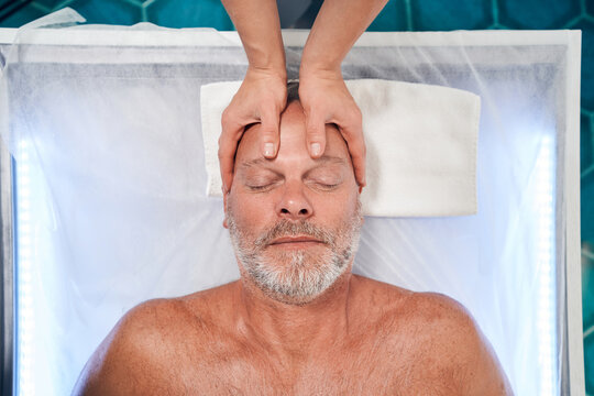 Man Receiving Professional Scalp Massage At Wellness Center