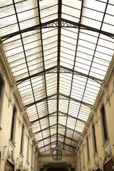 Glass roof. Ancient commercial gallery of Alessandria.Glass roof with gable roof of a gallery with shops in the center of the Piedmontese city. Alessandria, Piedmont, Italy.