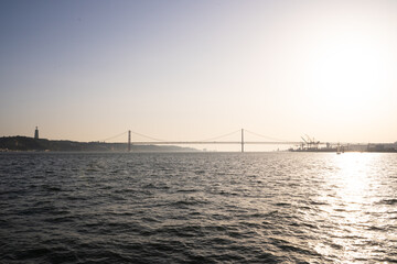 Rays of the sunset illuminating a river and a bridge
