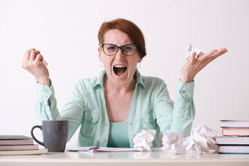 A young woman with glasses in a rage crudged the paper sheets