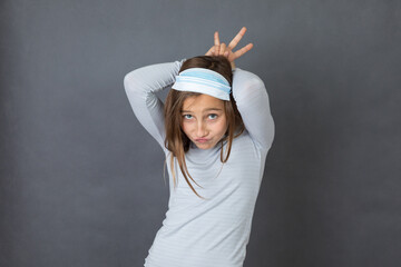 Portrait of a young girl with medical mask on her head on grey background. - 463842807