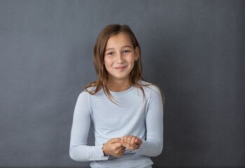Portrait of a young happy girl on grey background with space for text - 463842809