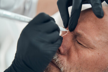 Male person having skincare procedure in cosmetology clinic