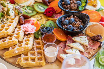 Delicious gourmet breakfast charcuterie board with waffles, fruits, and oatmeal