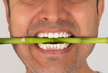Close up photo of brown skinned young adult man smiling. White and strong  teeth concept.