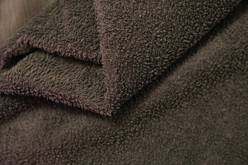 Fototapeta na wymiar Rolled, crumpled, brown towel, close up