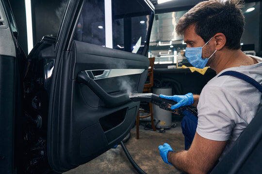 Man Cleaning Car Door Handle With Steam