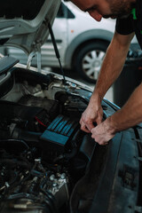 Fototapeta premium Car mechanic in a workshop working at car