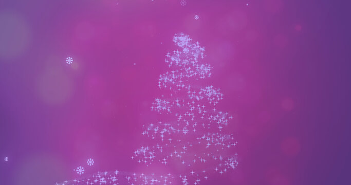 Image of snow falling over glowing christmas tree