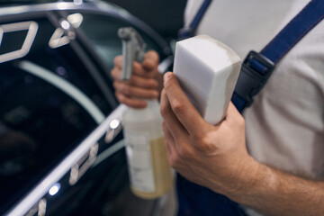 Sponge with dirt soaked into it in hand of repairman