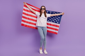 Full length photo of young cheerful girl happy positive smile hold usa flag independence patriotism isolated over violet background