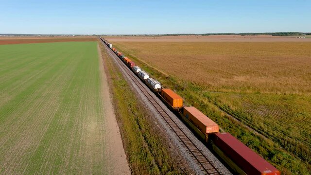 Transportation industry: freight train traveling on countryside, 4K UHD drone aerial footage.