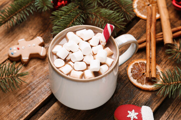 Delicious hot chocolate with marshmallows and  Christmas cookies on wooden table