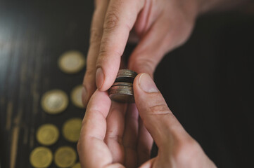 Fototapeta premium business man counting money. rich male hands holds and count coins of different euros on table