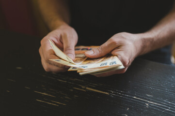 business man counting money. rich male hands holds and count cash banknotes of 50 euros bills or notes currency
