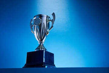 low angle view of winning trophy against blue background - obrazy, fototapety, plakaty