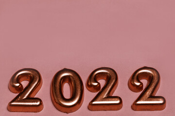 Festive New year and Christmas golden number 2022 on pink background