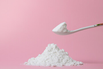 Isolated Powdered Sugar. Sugar powder on a pink background. Baking ingredient.