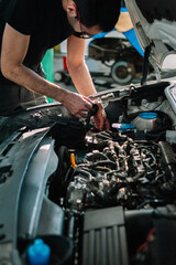 Car mechanic in a workshop working at car