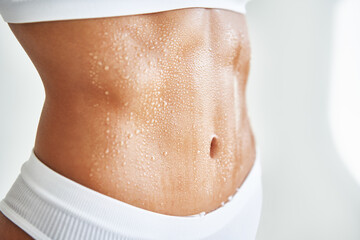 Close up belly of a beautiful sporty girl in drop of sweat or water on skin - 463855483