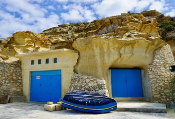 The fishing village of Dahlet Qorrot on the island of Gozo, Malta. Boathouses built in  the soft...