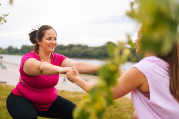 Medium shot of professional fitness female trainer giving personal training to overweight young...