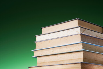 low angle view stack of books against green background