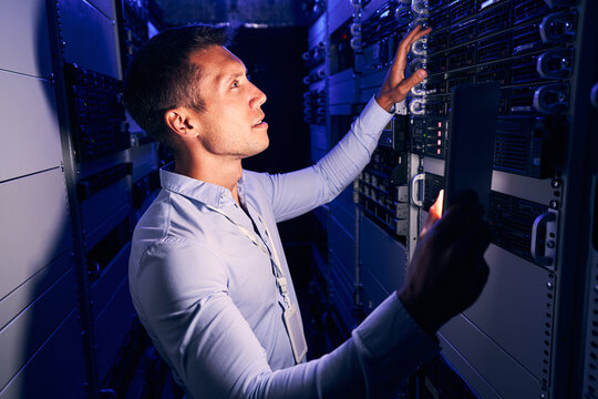 System administrator inspecting storage hardware in server room