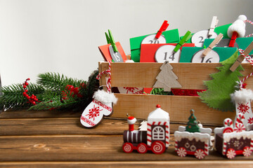 Christmas Advent calendar on the table, in a wooden box. Multicolored envelopes made by hand