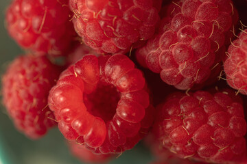 Ripe red raspberries on a plate.