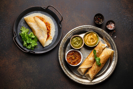 Traditional Indian rice pancakes Dosa with different dips chutney and seasonings
