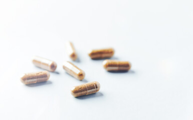 Ashwagandha (Withania somnifera) capsules. Bright paper background. Close up. Copy space. 