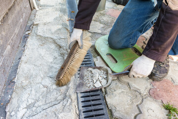 The builder removes the garbage and prepares a place for the repair of the foundation. Housework in the village.