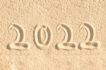 2022 written in the sand of a beach, new year travel greeting card