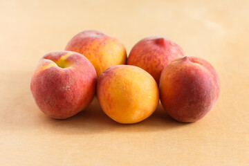 Fototapeta na wymiar five peaches on a brown table